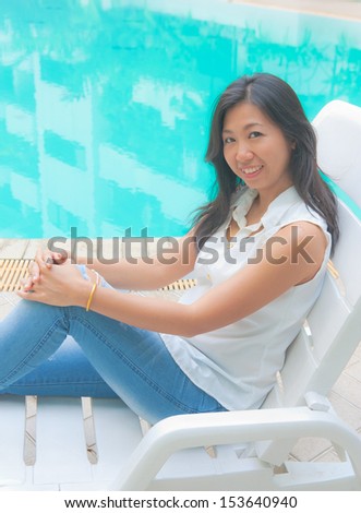Portrait of an Asian woman relaxing on a pool chair