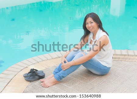 An Asian woman chill out beside a swimming pool