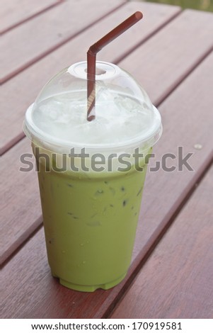 Plastic cup of icy milk green tea with cover