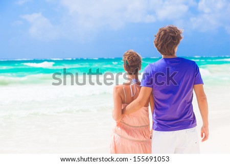 Couple walking and having fun on a tropical beach at Maldives