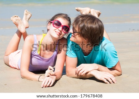 portrait of happy young couple in sunglasses enjoying their time on beach
