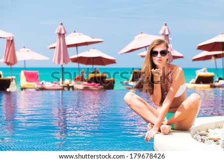 young woman near swimming pool blowing air kiss on poolside