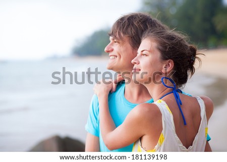 Portrait of happy young couple enjoying their time on tropical beach in the evening