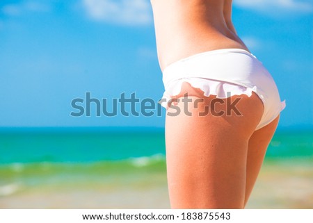 back view of fit young woman in white bikini