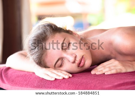 portrait beautiful young woman with flower in hair lying in spa