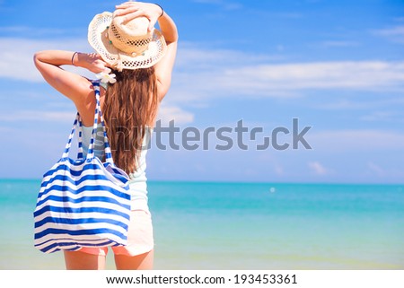 back view of a woman with bag at beach