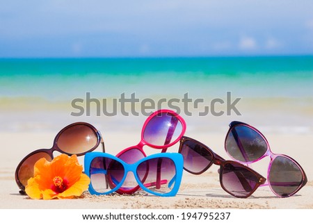 many sunglasses lying on tropical lying beach