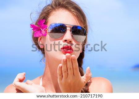 portrait of young beautiful woman with red lips blowing a kiss