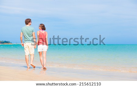 back view of couple walking at tropical beach