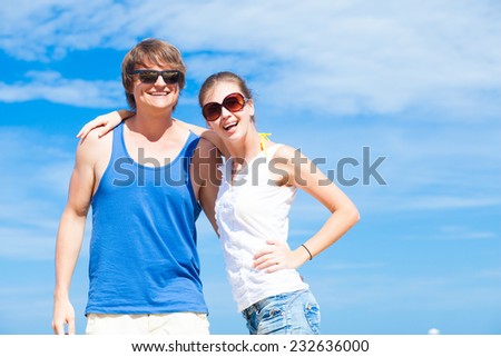 Closeup of happy young couple in sunglasses enjoying their time on tropical beach