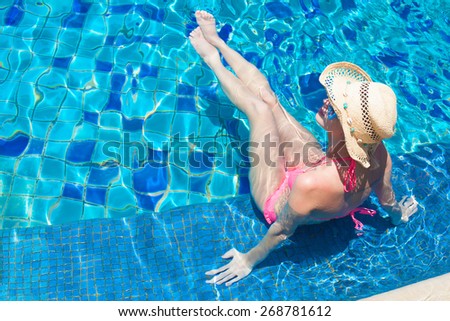 young beautiful woman in straw hat relaxing in spa pool