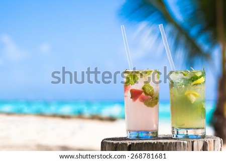 two glasses of chilled cocktail mohito and sunglasses on table near the beach
