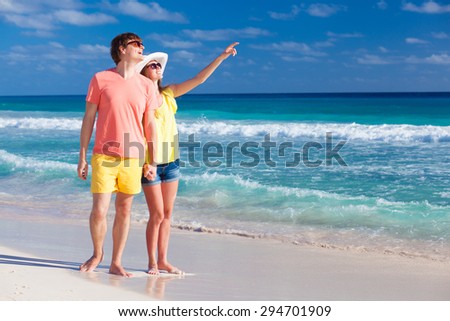 happy romantic young couple pointing at the sky