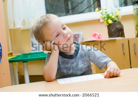 The Small artist. The Boy sits at the table and draws and sleeps.