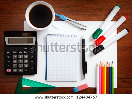 Desk with sheet of paper and stationery objects seen from above