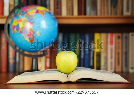 apple and book on background bookcase