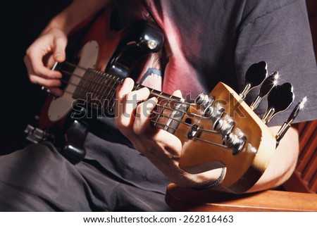 guy playing bass, guitar closeup