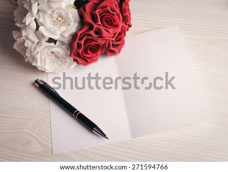 blank card with a pen, white and red roses