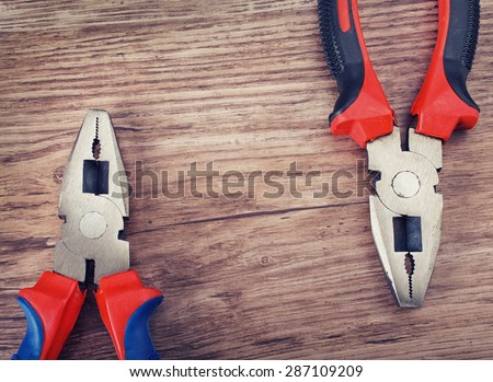 combination cutting pliers on wooden  background, copy space
