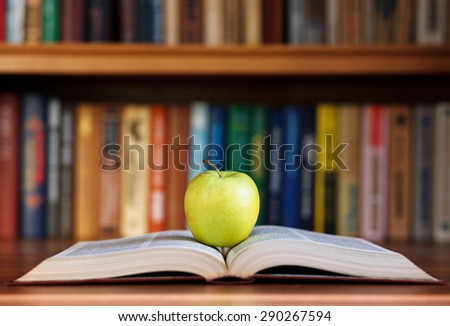 apple and book on background bookshelf