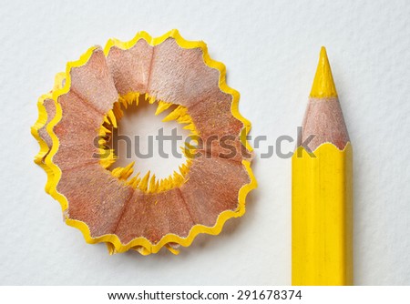 yellow pencil and shavings on white paper background