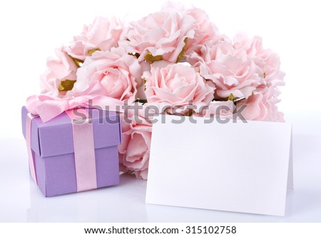 Greeting card with pink flowers and a purple gift box with ribbon and bow on a white background