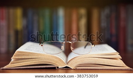 glasses and book on background bookcase