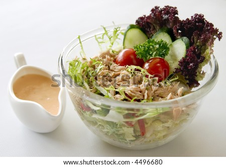 Fresh tuna salad in a bowl with dressing on the side