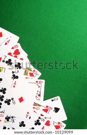 Playing cards spread out on one corner. Copy space for your design.