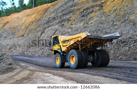a panning shot a dump truck working on coal site
