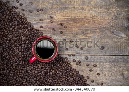 Coffee beans and red coffee cup on wooden background