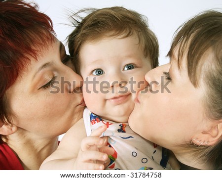 Happy mom and its sister kiss kiss on both cheeks the small son