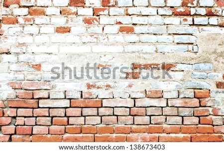 Aged wall of red and white bricks with the stain in the middle