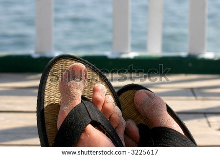Sandy feet of a relaxing person at the beach