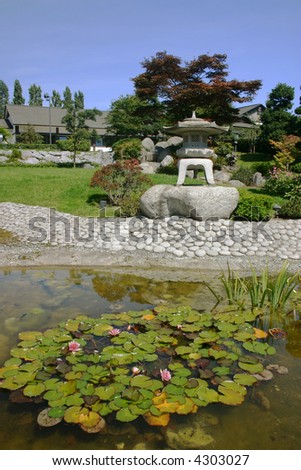 traditional japanese botanical garden with lantern at a pond with water lilies
