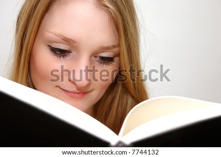 young girl puts her nose in a book