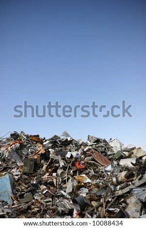 junk yard with old plastic and scrap metal in front of blue sky