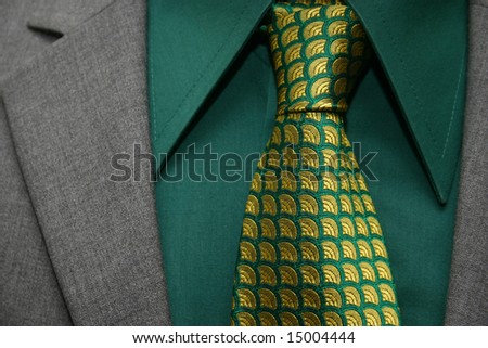 green and yellow necktie, grey suit and green collar