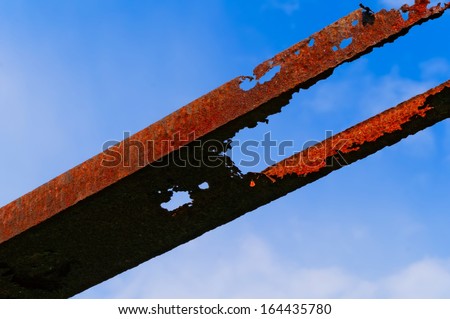 Rusty metal beam against bright blue sky