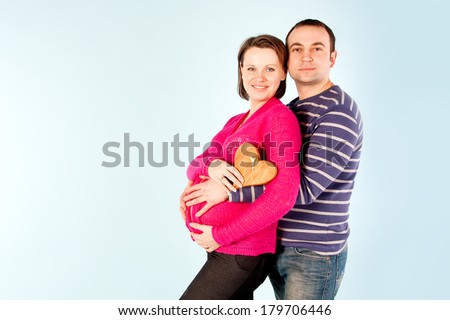 Young pregnant woman and man. Pregnant family. Studio shot