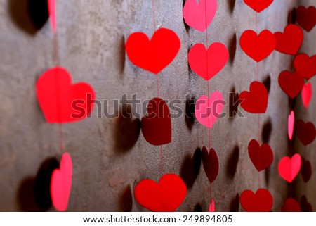cute red hearts on the wall with texture.Serce paper on a rope