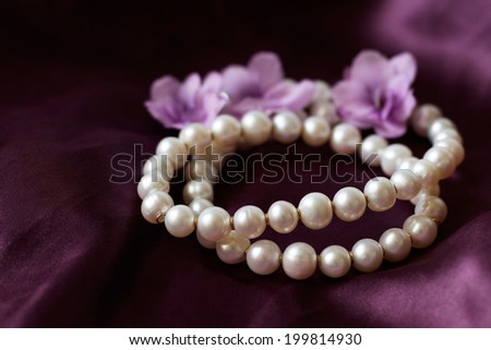 Pearl necklace on purple background