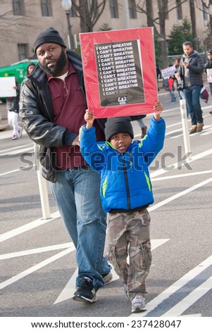WASHINGTON - DECEMBER 13: A protester holds a sign during a march against police shootings and racism during a rally in  Washington, DC on December 13, 2014