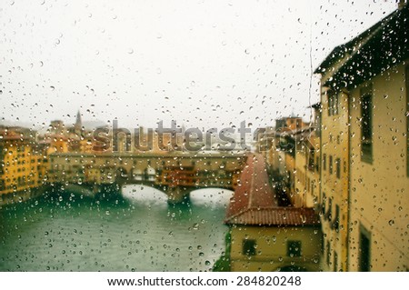 Ponte Vecchio - defocussed view through the window covered in rain, focus on raindrops, Florence, Italy