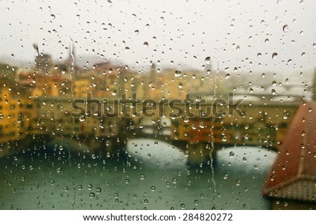Ponte Vecchio - defocussed view through the window covered in rain, focus on raindrops, Florence, Italy