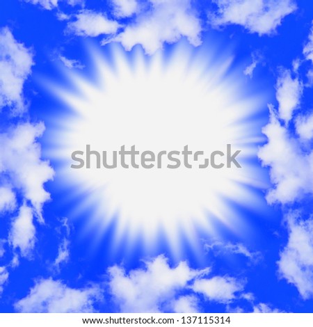 A blinding burst of light in a bright blue sky framed by fluffy white clouds.