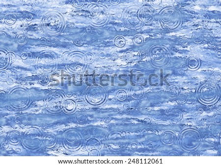 A beautiful close up of rain associated ripples on water in blue