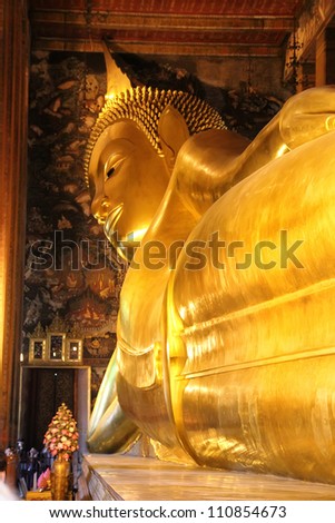 BANGKOK, THAILAND - JANUARY 12: Detail of the Reclining Buddha statue in temple Wat Pho in Bangkok, thailand at January 12, 2012. Statue is 15 m high and 43 m long with his right arm supporting head.