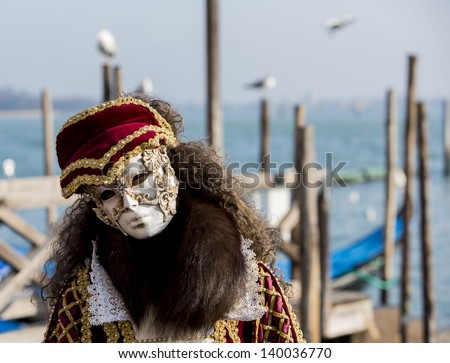 VENICE, ITALY - FEBRUARY 10: Unidentified person with traditional Venetian carnival mask in Venice, Italy at February 10, 2013. At 2013 it is held from January 26th to February 12th.