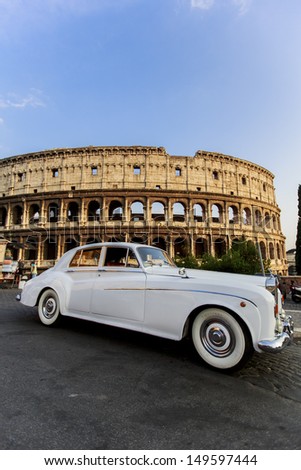 ROME, ITALY - JULY 18: Rolls Royce car in front of Colosseum in Rome, Italy on July 18, 2013. its construction started in 72 AD under the emperor Vespasian and was completed in 80 AD under Titus.